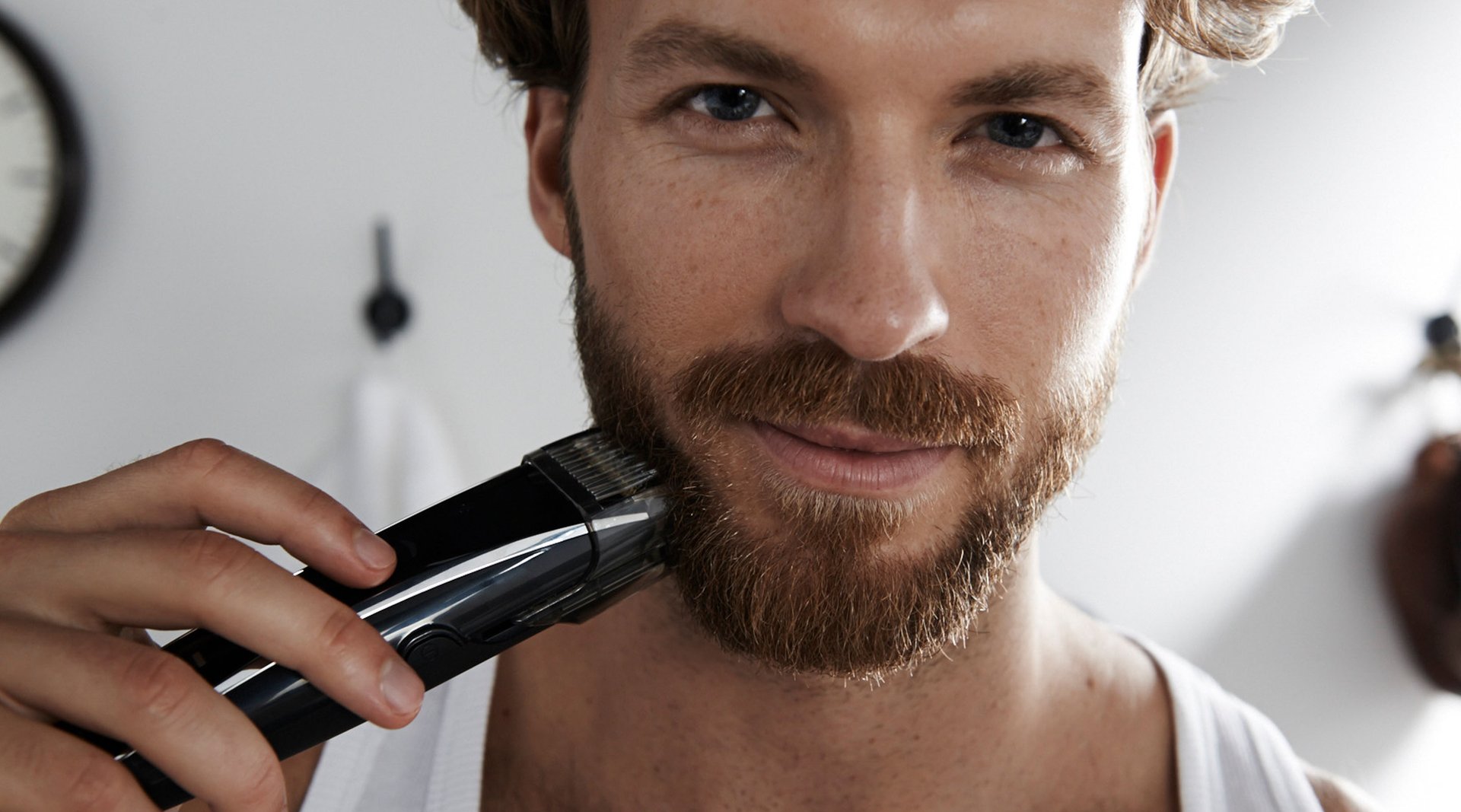 Mann mit Rasierapparat und Aftershave